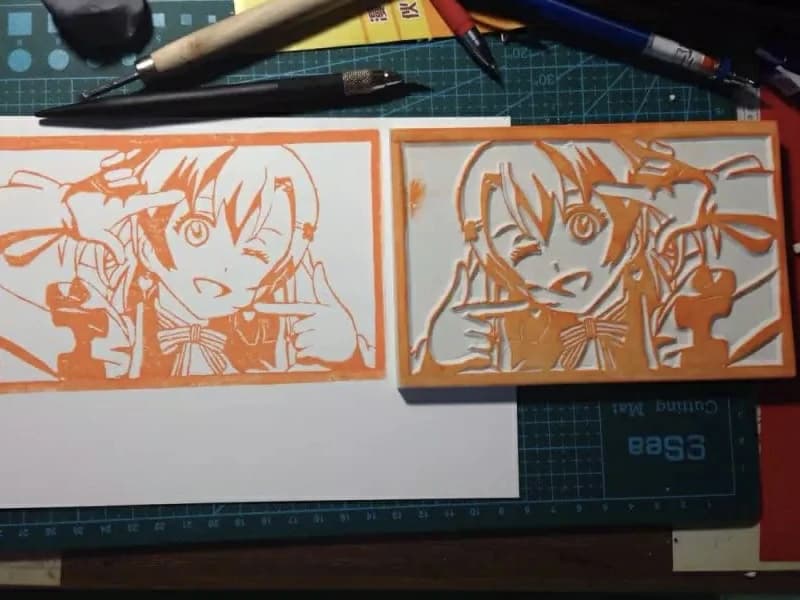 Hand-carved rubber stamp artwork in orange